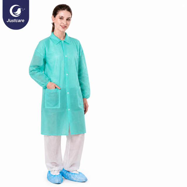Justcare snap‑fastened lab coat, mint green disposable non‑woven lab coat with pockets, model shot on plain white background