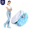 Justcare light blue PP shoe covers with white non‑slip sole, female model wearing disposable shoe covers, white background product shoot