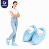 Justcare disposable PP+POE shoe covers, female model wearing blue shoe covers over shoes