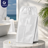 Folded Justcare disposable spunlace bath gown, soft non‑woven spa wrap on marble table